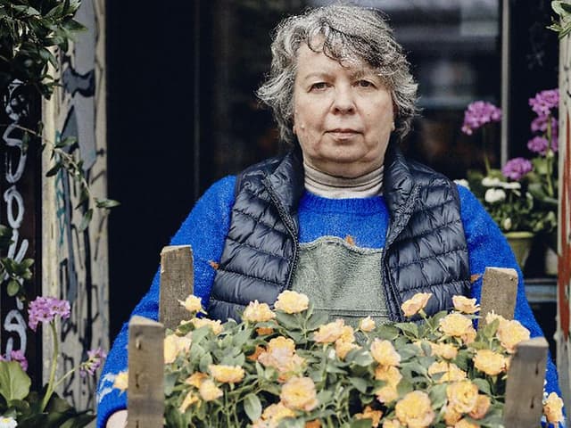 Kvinnelig blomsterhandler som holder en boks med blomster