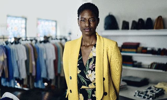 Kvinde i gul blazer i en tøjbutik