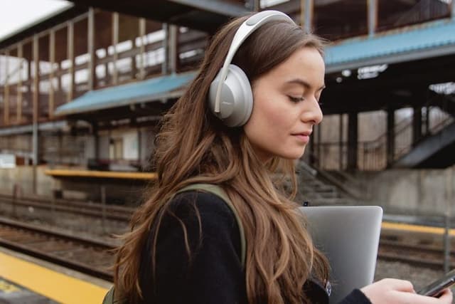 Woman with headphones on train station