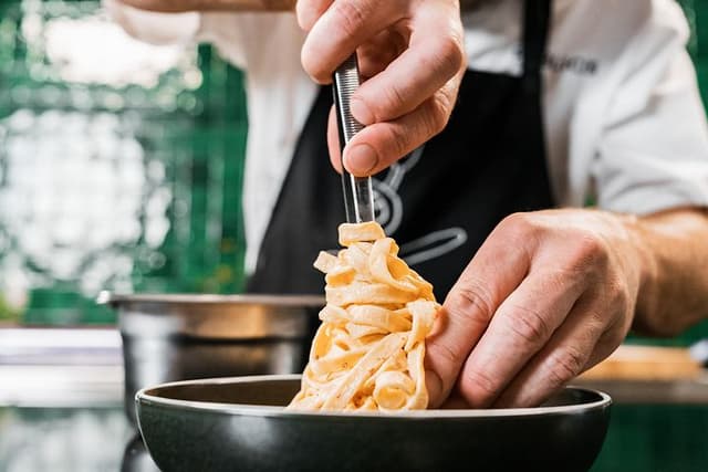 Chef plating cooked pasta
