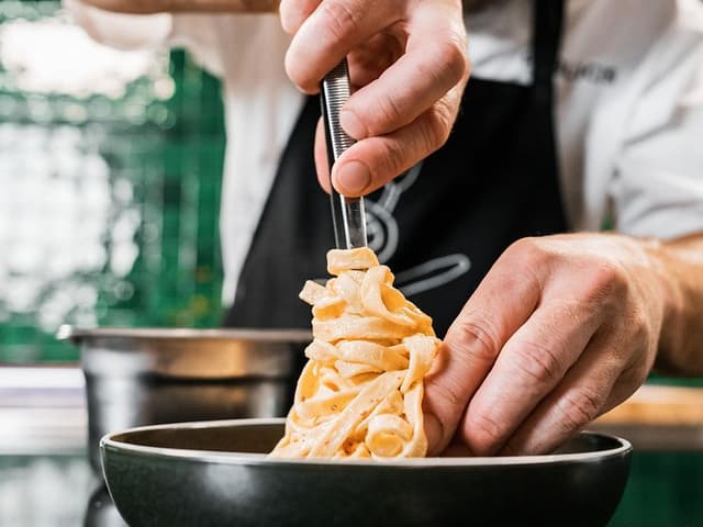 Chef plating cooked pasta