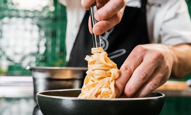Chef plating cooked pasta