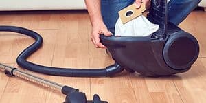 Man removing a bag from a vacuum cleaner