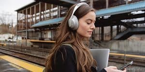 Kvinde med hovedtelefoner på en togstation