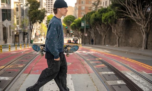 Man with a skateboard wearing JBL headphones