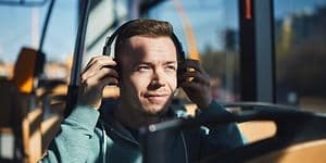 Man on a bus putting on headphones