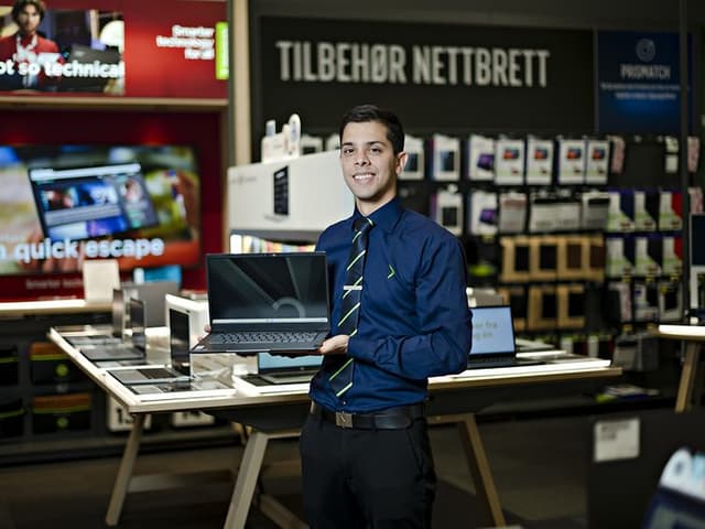 Elkjøp-selger som holder en Google Chromebook