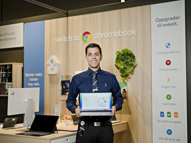 Google - Chromebook - Elkjøp salesman in store holding a chromebook