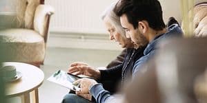 Man and old woman looking at a tablet