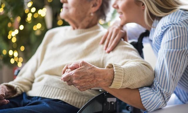 Woman holding the hand of an older woman