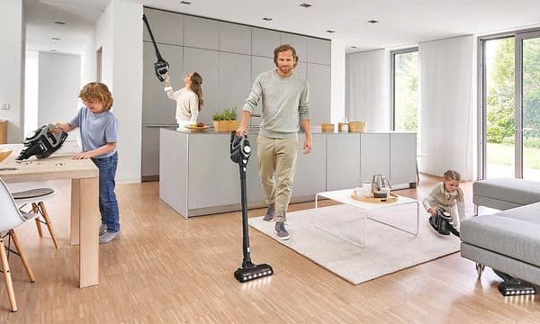 Familj som städar ett kök med var sin Bosch Unlimited serie 8 dammsugare