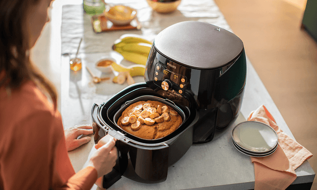 Woman adding food in air fryer