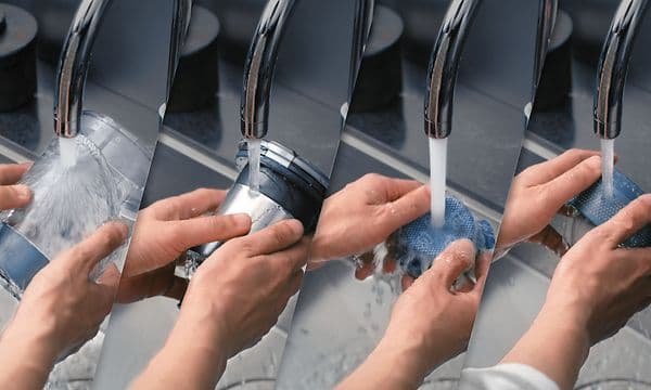 Händer som rengör delar av Samsung Jet skaftdammsugare