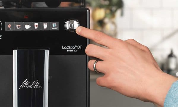 Hånd, der trykker på en knap på Melitta kaffemaskine