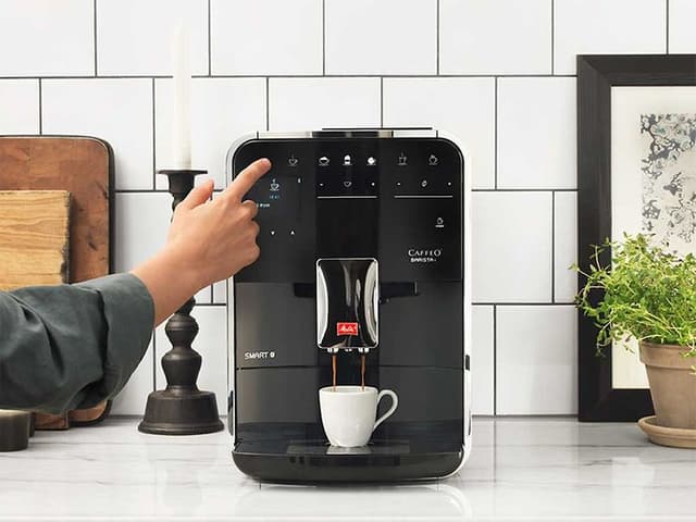 En kvinne som bruker Melitta Barista T espressomaskin