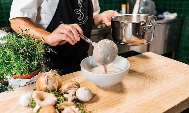 SDA - Cooking - chef pouring vegetable soup from a pot to a bowl