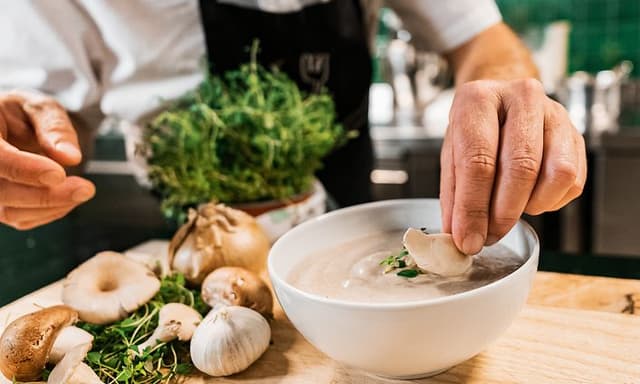 SDA - Cooking - chef arranges vegetable soup in a bowl