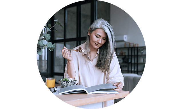 Woman eating salad whilst reading