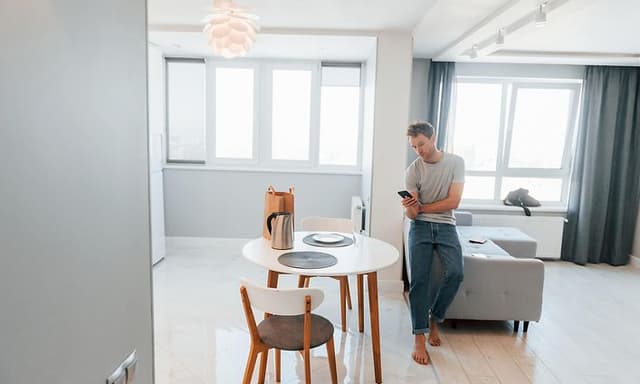 Mand der styrer sit smart hjem med sin telefon