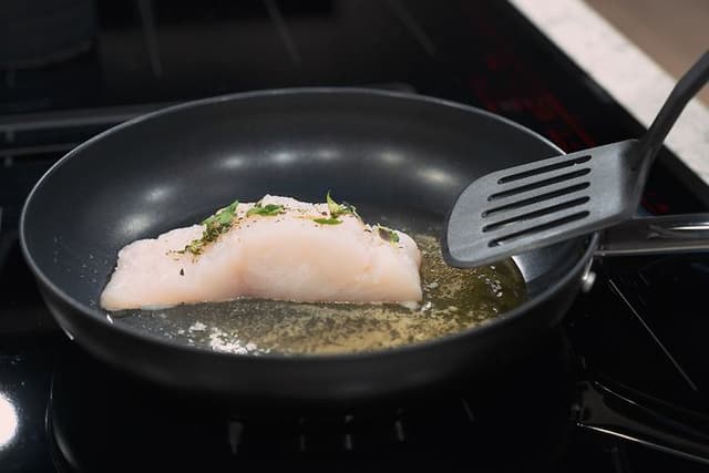 SDA - Stegepande - Fisk der bliver stegt på en stegepande med en paletkniv i plastic