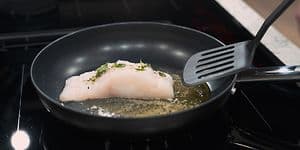 SDA - Stegepande - Fisk der bliver stegt på en stegepande med en paletkniv i plastic