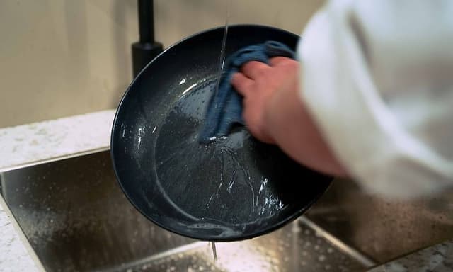 SDA - Stegepande - Mand der vasker en stegepande op i hånden