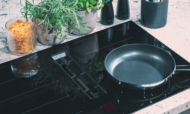 A frying pan placed on an inbuilt hob