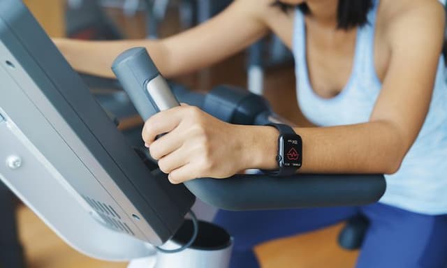 Telecom - How to connect your heart rate belt to your sports watch - A woman on an exercise bike