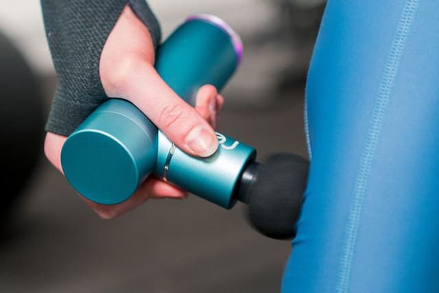 SDA - Massage - Picture of a woman using a massage gun on her calf