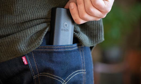 A hand putting iFixit Minnow Precision Bit Set in backpocket