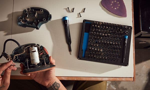 Man som fixar elektronisk apparat