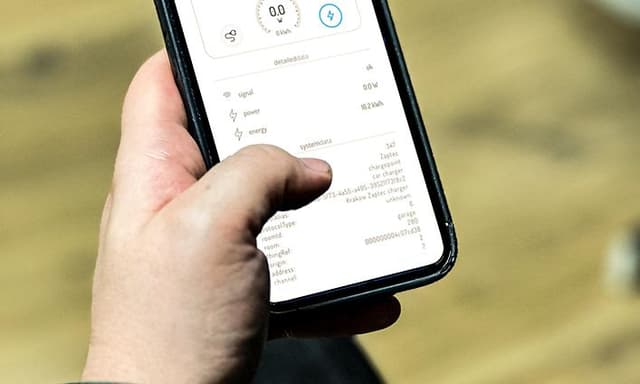 MDA - Cars and motor bikes - Man holding a smarthpone with a charging app