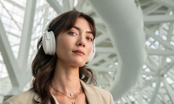Bose - Kuulokkeet - Nuori nainen valkoiset Bose-kuulokkeet päässään
