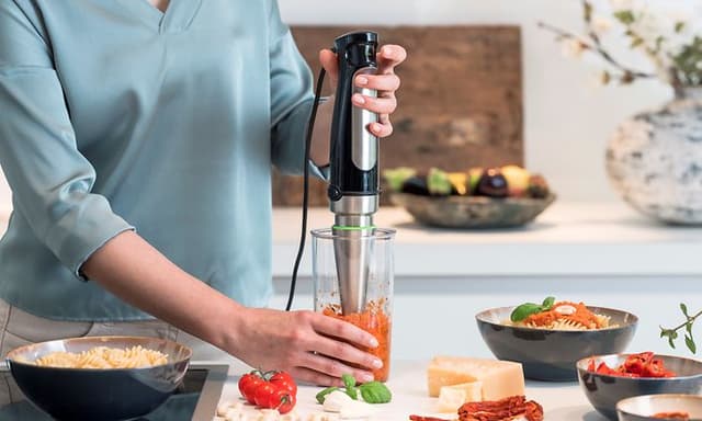 Kvinne som lager pastasaus med Braun stavmikser