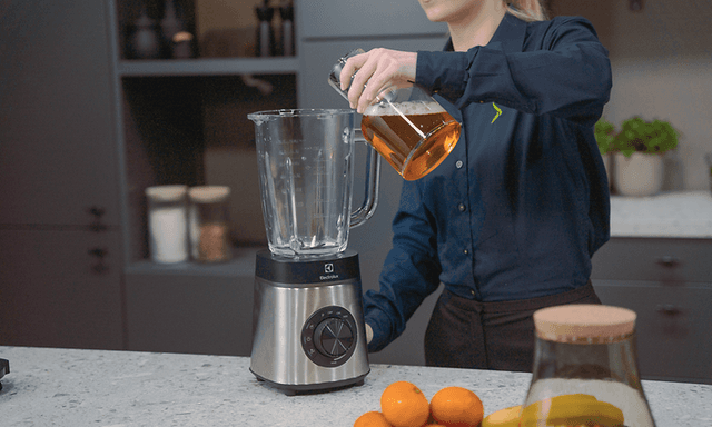 SDA - Blender - A woman pouring a liquid into a blender