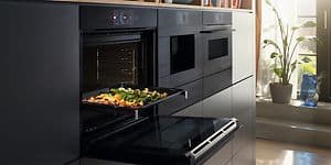 Bosch Accent line ugn med öppen lucka och en bakplåt med grönsaker