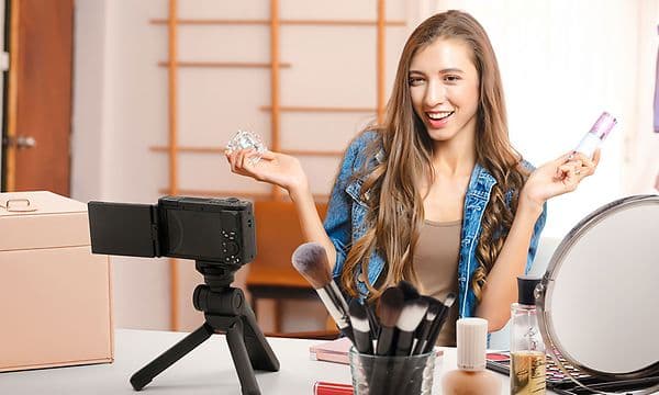 En ung kvinne som filmer seg selv med Sony ZV-1F-kamera