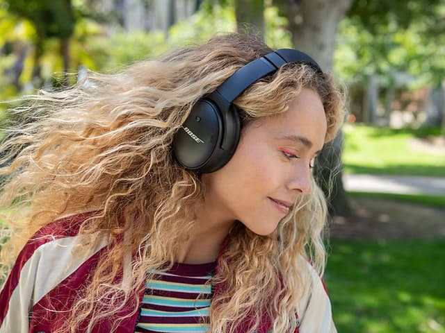 Girl wearing black Bose headphones