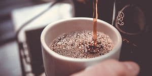 Kaffekopp som fylles fra kaffemaskin