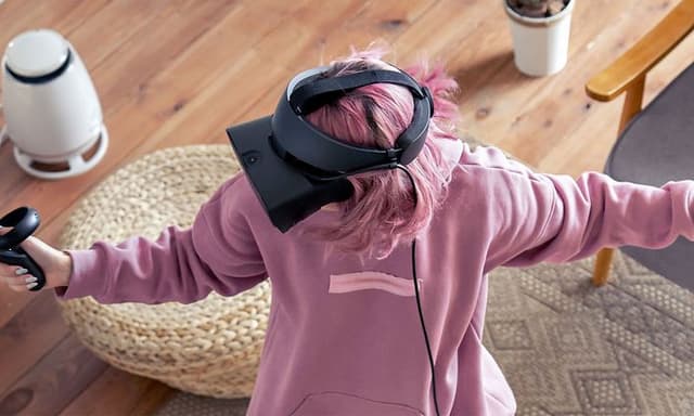 Gaming - VR Gaming - Kvinde der spiller med et VR-headset i en stue