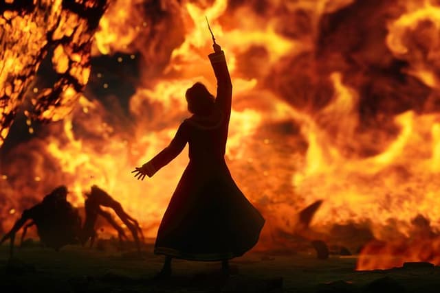 Skjermbilde fra spillet Hogwarts Legacy som viser kamp mot en edderkopp rundt flammer