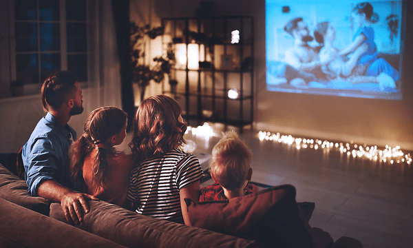 Hemmabio: Familjen tittar på en film genom en projektor på en duk.