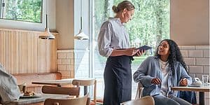 Elkjøp B2B Hospitality - En servitrice tager imod en ordre fra en gæst på en café