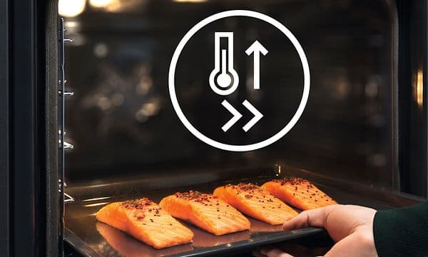 Laksefileter på et brett settes i en Electrolux-ovn med Fast Heat Up-funksjon