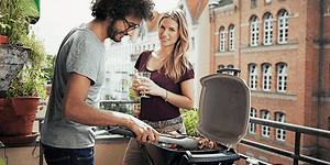 Pariskunta grillaa parvekkeella