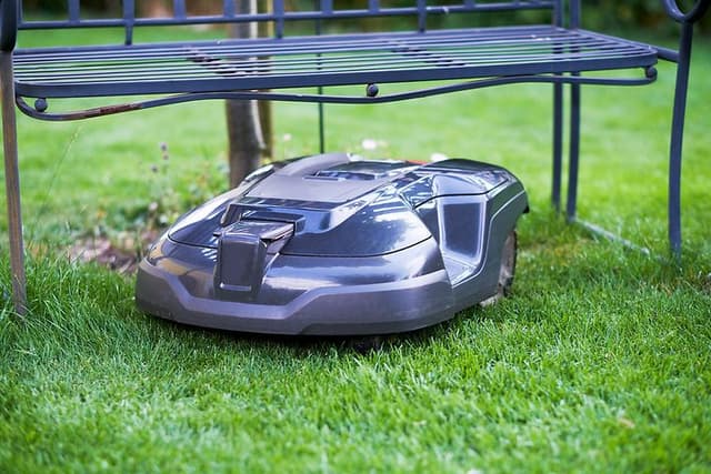 Robot lawn mover under a trampoline