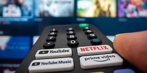 Fjernbetjening med Netflix -, Youtube- og Amazonknapper, peget mod et tv 