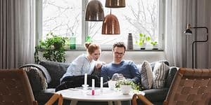 Couple sitting in sofa looking at phone