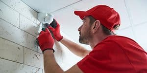 Man installing motion sensor on wall