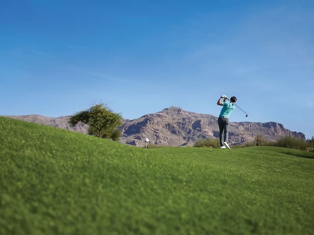 Telecom - Wearables - Smartwatch - Man golfing on a pitch with a Garmin smartwatch suitable for golf on his wrist